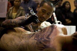 Tattoo artist working on a body suit